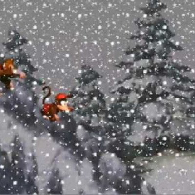 Screenshot from Donkey Kong Country showing characters in a snowy level with falling snowflakes and evergreen trees.