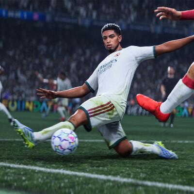EA SPORTS FC 27: Player in white kit makes a sliding tackle for the ball near the sideline as an opponent's red-cleated foot challenges, packed stadium crowd blurred in the background.