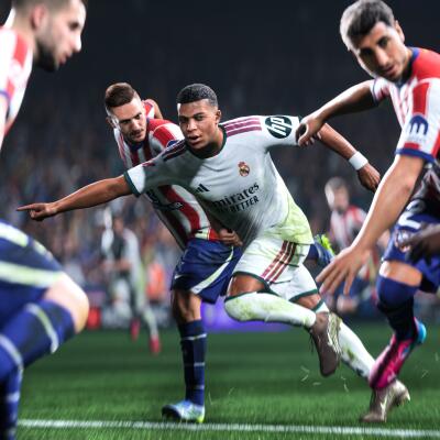 EA SPORTS FC 27 screenshot: Real Madrid forward in white kit lunging past red-and-white–striped defenders on a rain-speckled pitch under bright stadium lights.