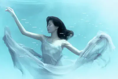 Ethereal underwater portrait of a woman in a flowing white dress, hair drifting and arms extended — LE SSERAFIM visual style.