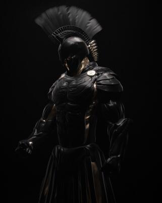 Black-armored ancient Greek warrior in plumed helmet with gold accents on dark background, image for The Odyssey (2026).