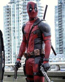 Deadpool from X-Men Origins: Wolverine in a red-and-black suit, armed with katanas and pistols, standing on an urban rooftop with high-rise buildings in the background.