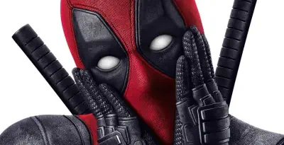 Deadpool close-up in a red-and-black mask with white eye lenses, gloved hands on his cheeks and twin swords on his back — promotional image for X-Men Origins: Wolverine.